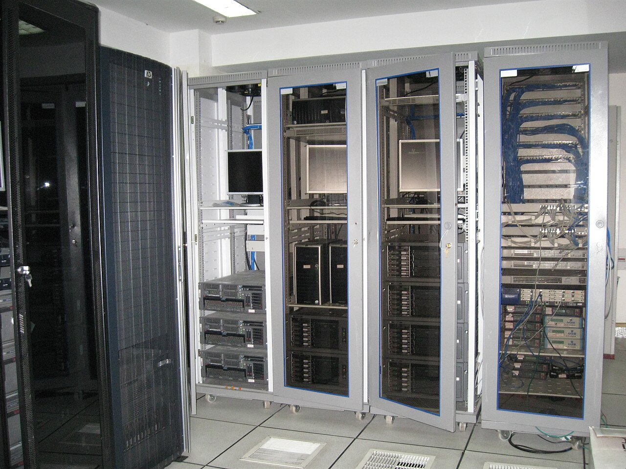 Bên trong một phòng máy chủ với hàng chục tủ rack thiết bị mạng và máy tính